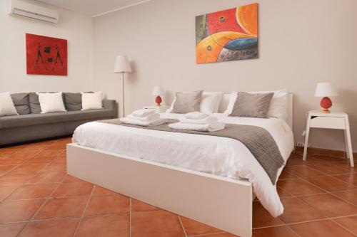uma grande cama branca num quarto com um sofá em Madinah apartments em Palermo