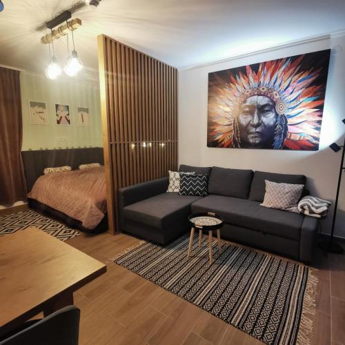 a living room with a couch and a bed at Kai Apartman in Kopaonik