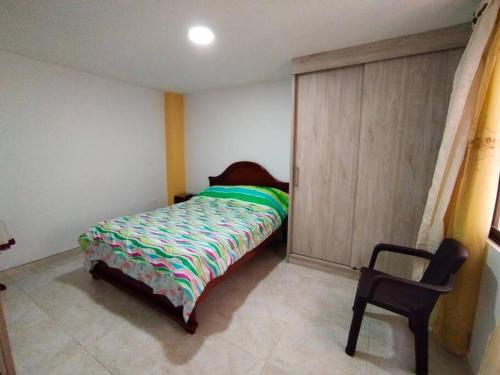 1 dormitorio con 1 cama y 1 silla en Hermoso y nuevo apartamento en Santa Rosa de Cabal, en Santa Rosa de Cabal