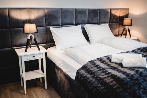 um quarto com uma cama e uma mesa de cabeceira com 2 candeeiros em Apartament Rezydencja Park 3 em Mielno