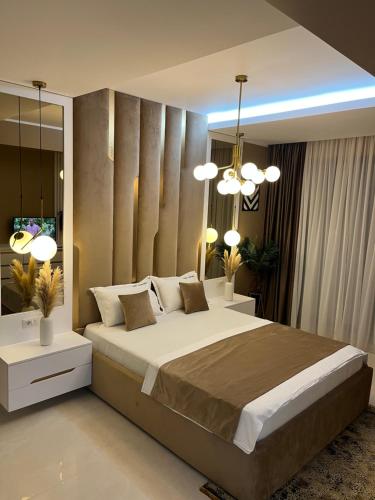a bedroom with a large bed and two lights at SAS 2 Luxury Apartments in Mamaia