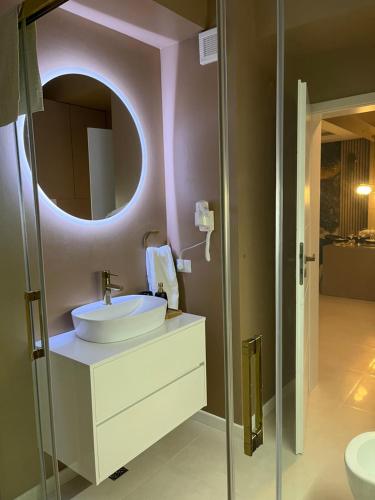 SAS 2 Luxury Apartments في مامايا: حمام مع حوض ومرآة