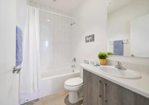 een witte badkamer met een toilet en een wastafel bij Amazing 3BR Townhouse In Miami in Golden Glades