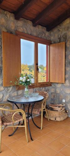 mesa y sillas en una habitación con ventana en Casa Rural Roja, en Cebreros