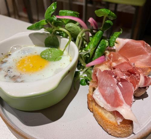 a plate with an egg and a sandwich and a salad at LA PLANETTE in Aussonne