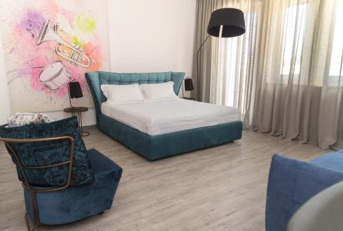 a bedroom with a bed and a couch and a chair at I Bannisti in Santeramo in Colle