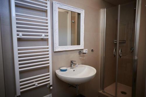 a bathroom with a sink and a shower with a mirror at I Bannisti in Santeramo in Colle