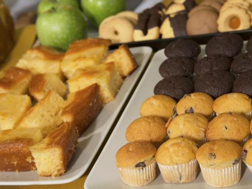 a table topped with trays of different types of desserts at My One Hotel Bologna in Bologna