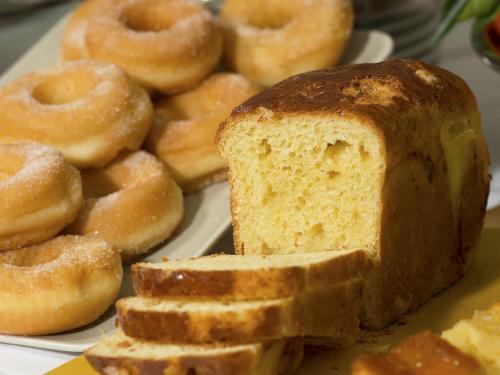 a plate with a loaf of bread and a pile of donuts at My One Hotel Bologna in Bologna