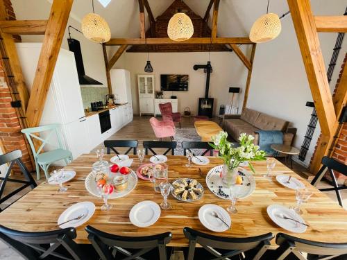 een eetkamer met een grote houten tafel en stoelen bij Baryczanka SLOW HOME in Przygodzice