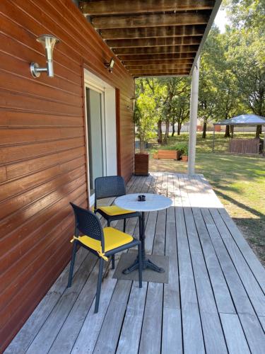 a patio with two chairs and a table on a deck at LA PLANETTE in Aussonne