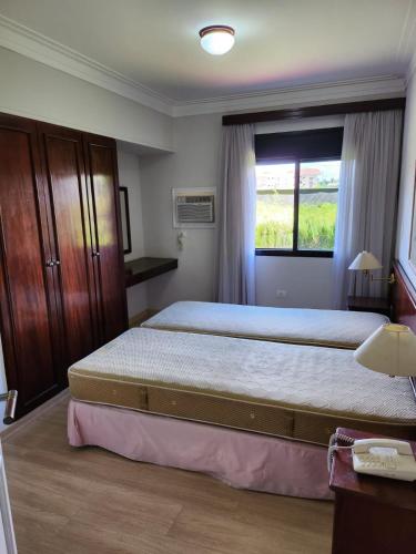a bedroom with a large bed and a window at AGUAS DE SÃO PEDRO VIP in Águas de São Pedro