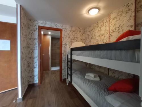 a bedroom with two bunk beds and a hallway at Apartamento superior monte oiz in Sierra Nevada