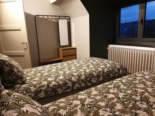 1 dormitorio con cama, espejo y ventana en Le Marsouin, en Sangatte