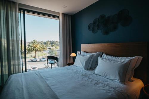 Schlafzimmer mit einem Bett und einem Fenster mit Aussicht in der Unterkunft XPT Águeda - Boutique Apartments in Águeda