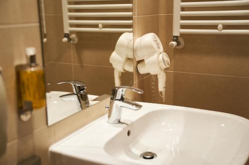 a bathroom sink with a hair dryer and a mirror at Petrodava ONE in Piatra Neamţ