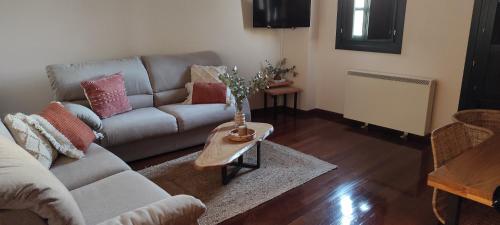 a living room with a couch and a table at Apartamento Portovello con vistas al río in Allariz