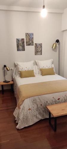 a bedroom with two beds and a table and lamps at Apartamento Portovello con vistas al río in Allariz