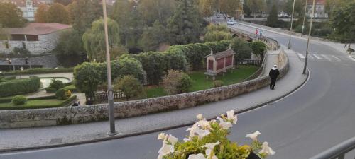 un hombre caminando por una calle al lado de una carretera en Apartamento Portovello con vistas al río, en Allariz