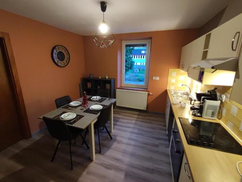 une cuisine avec une table et des chaises dans une pièce dans l'établissement Appartement 5 personnes à deux kilomètres des pistes, à La Bresse