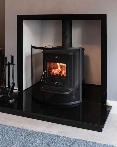 a black stove is sitting in a room at Glen Burren House in Newcastle