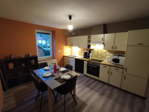 een kleine keuken met een tafel en stoelen. bij Appartement 5 personnes à deux kilomètres des pistes in La Bresse