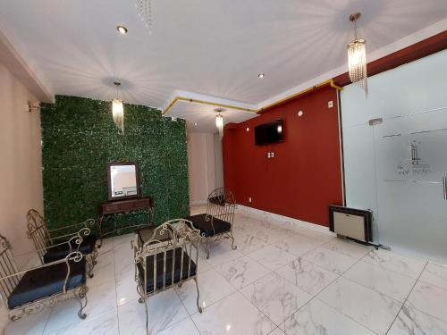 a room with a green wall with chairs and a mirror at Hotel Boutique Vivenzo in La Paz