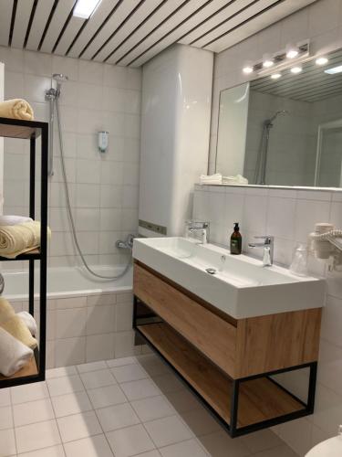 a bathroom with a sink and a mirror and a tub at Appartement Posthäusl in Sölden