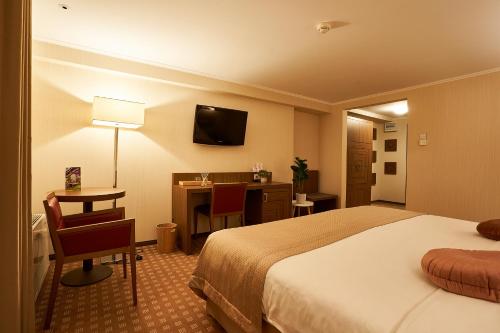 a hotel room with a bed and a desk at Petrodava ONE in Piatra Neamţ