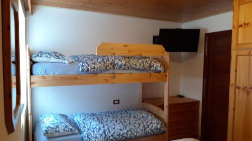 two bunk beds in a room with a television at CasaMau Bilo in Pera