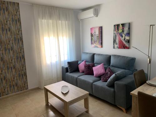 a living room with a blue couch with purple pillows at Estrella in Huelva