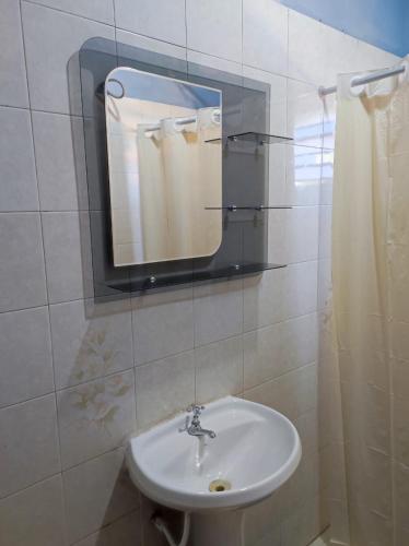 a bathroom with a sink and a mirror at Pequeño departamento in Asunción