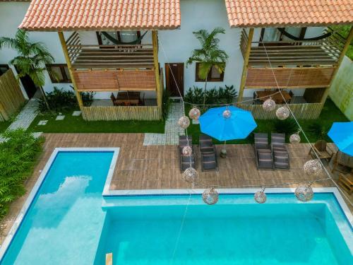 an overhead view of a pool with chairs and an umbrella at Pousada Vila Mangaba in Arraial d'Ajuda