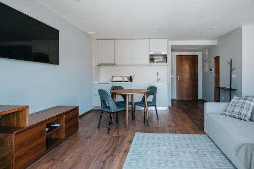 a living room and kitchen with a table and a couch at XPT Águeda - Boutique Apartments in Águeda