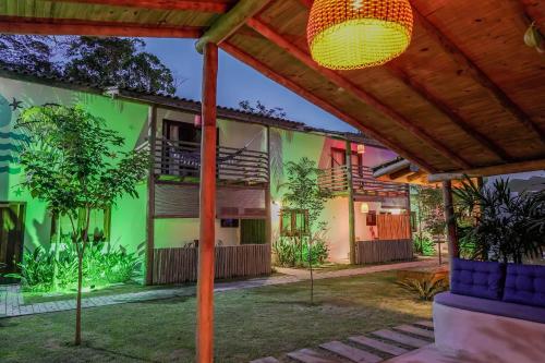 an exterior view of a house with green at Pousada Vila Mangaba in Arraial d'Ajuda