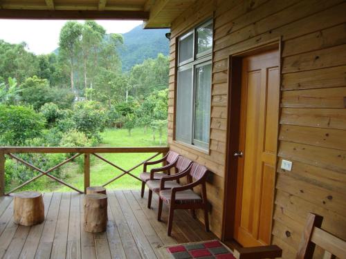 a porch of a cabin with two chairs and a window at Taroko Sialin Coffee Farm Homestay in Xiulin