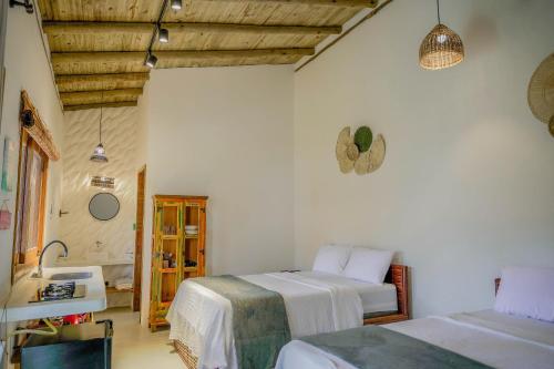 a bedroom with two beds and a sink at Pousada Vila Mangaba in Arraial d'Ajuda