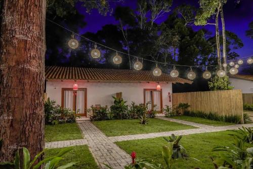 a house with christmas lights in the yard at Pousada Vila Mangaba in Arraial d'Ajuda