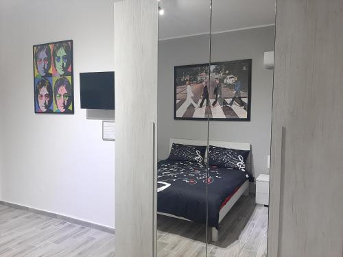 1 dormitorio con 1 cama con pared de cristal en THE HOME OF MUSIC STARS, en Catania