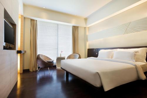 En eller flere senger på et rom på Novotel Manado Golf Resort & Convention Center