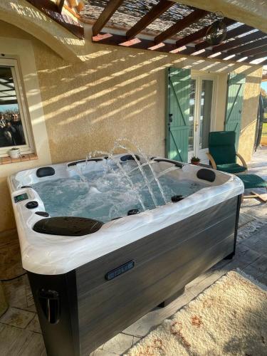 un bain à remous installé à l'extérieur d'une maison dans l'établissement Le Palmier de Mira - entre Uzège et Cévennes, à Saint-Chaptes