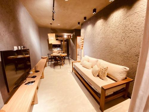 uma sala de estar com um sofá e uma sala de jantar em Villas Patacho - R E dos Milagres Apto H001 em Porto de Pedras