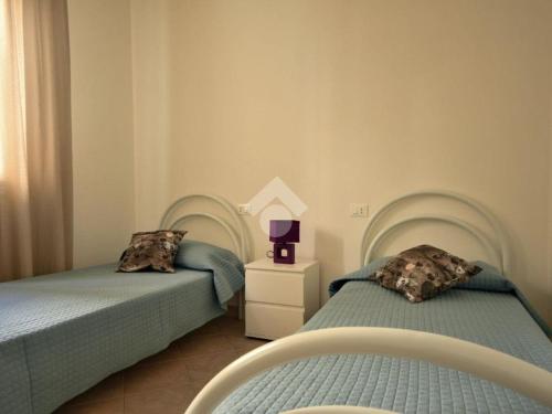 2 letti posti uno accanto all'altro in una camera da letto di Casa Arborea a Castelsardo