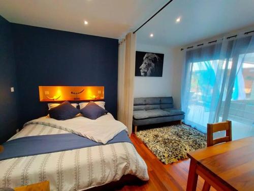 a bedroom with a bed and a table and a window at Villa Lou Santen Guadeloupe in Saint-François