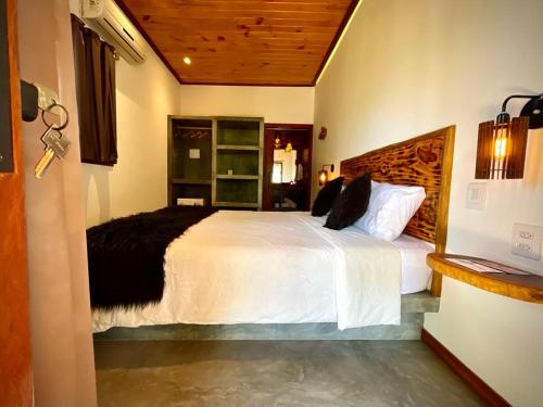 a bedroom with a large white bed in a room at Casa Palmeira in Pipa
