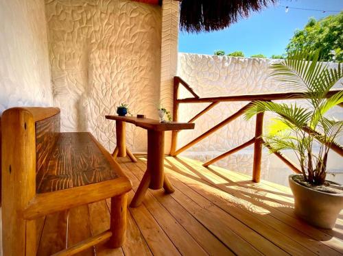 una veranda in legno con tavolo e pianta in vaso di Casa Palmeira a Pipa