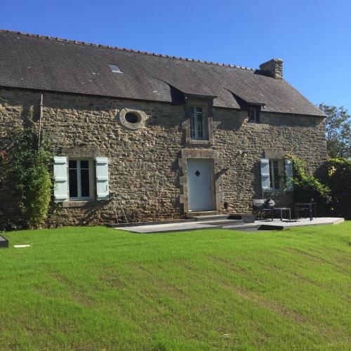 an old stone house with a grass yard at les demeures de Kerbosser in Ploeren