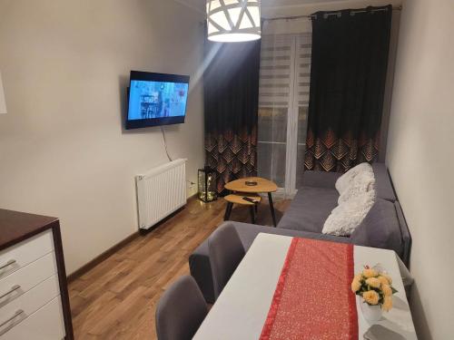 - un salon avec un canapé et une table dans l'établissement Apartament Grunwaldzka, à Olecko