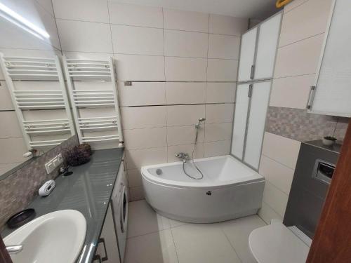 y baño con lavabo, aseo y bañera. en Apartament Grunwaldzka en Olecko