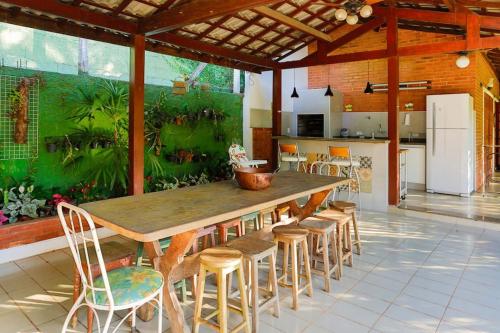 a kitchen with a large wooden table and chairs at LINDA CHACARA EM CONDOM 30 MIN DE SP piscina climatizada, churrasqueira, wifi, 5 quartos, amplo jardim in Cajamar